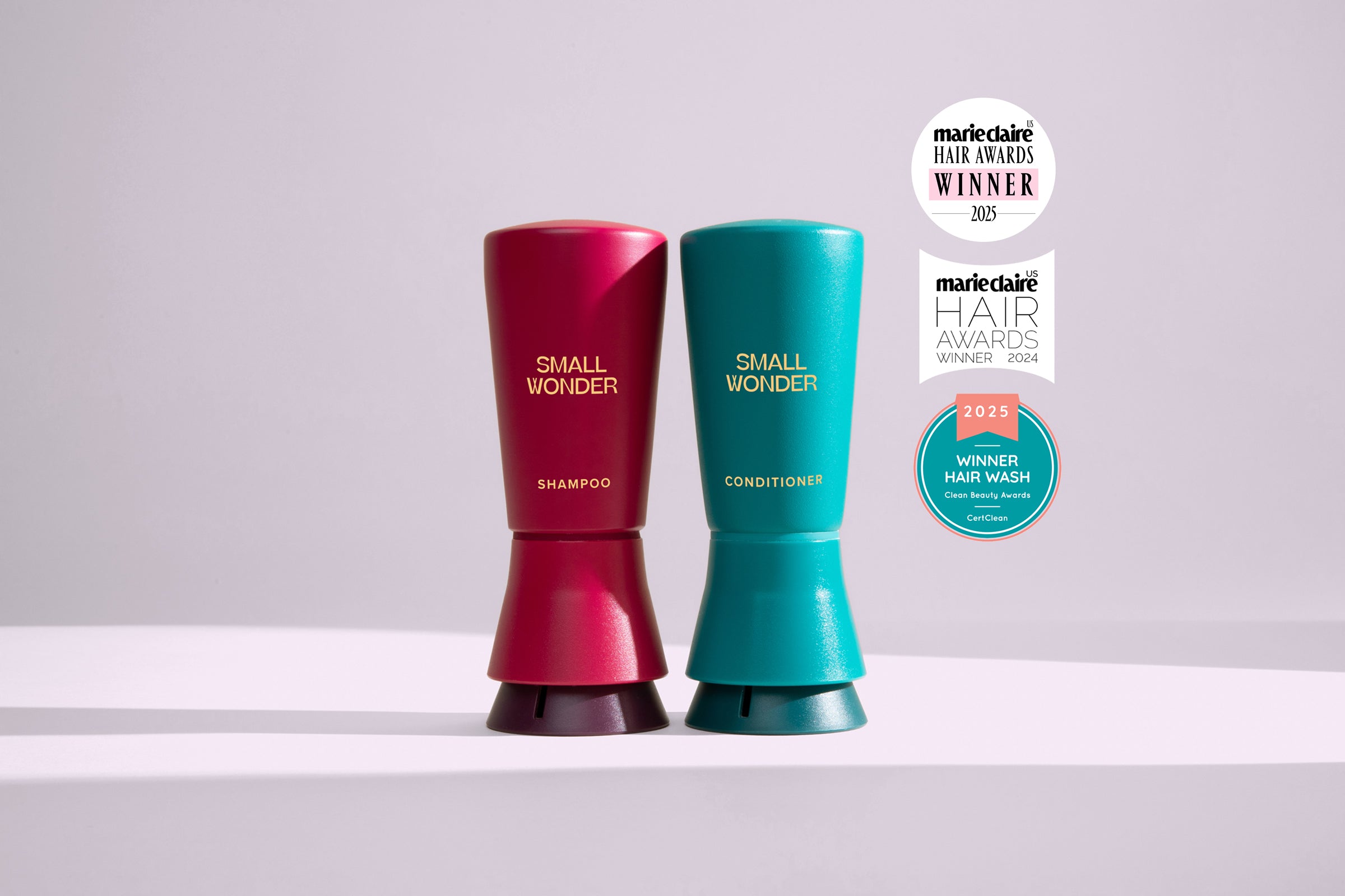 Two bottles of 'Small Wonder' shampoo and conditioner with awards on a light gray background