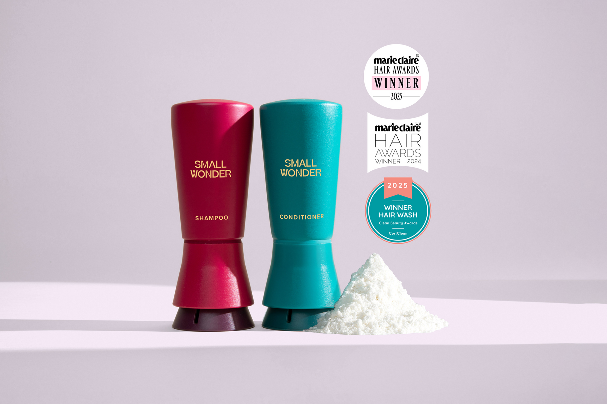Red and teal 'Small Wonder' shampoo and conditioner bottles with awards on a light purple background