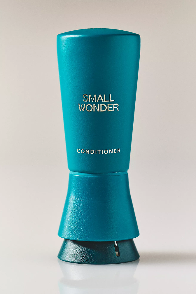 Blue bottle labeled 'Small Wonder Conditioner' on a light background