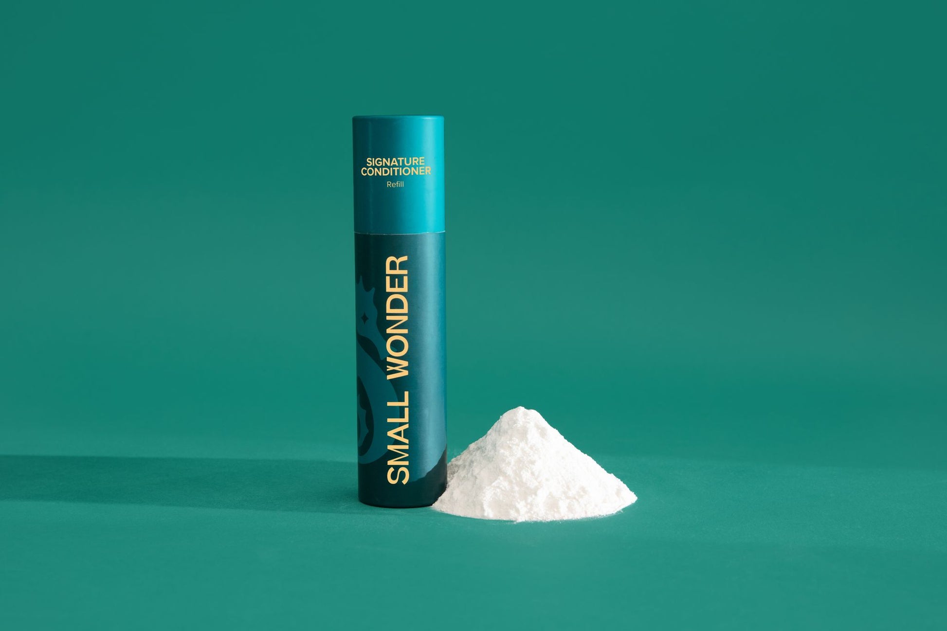 Teal cylindrical container labeled 'Small Wonder Conditioner' on a green background & white powder
