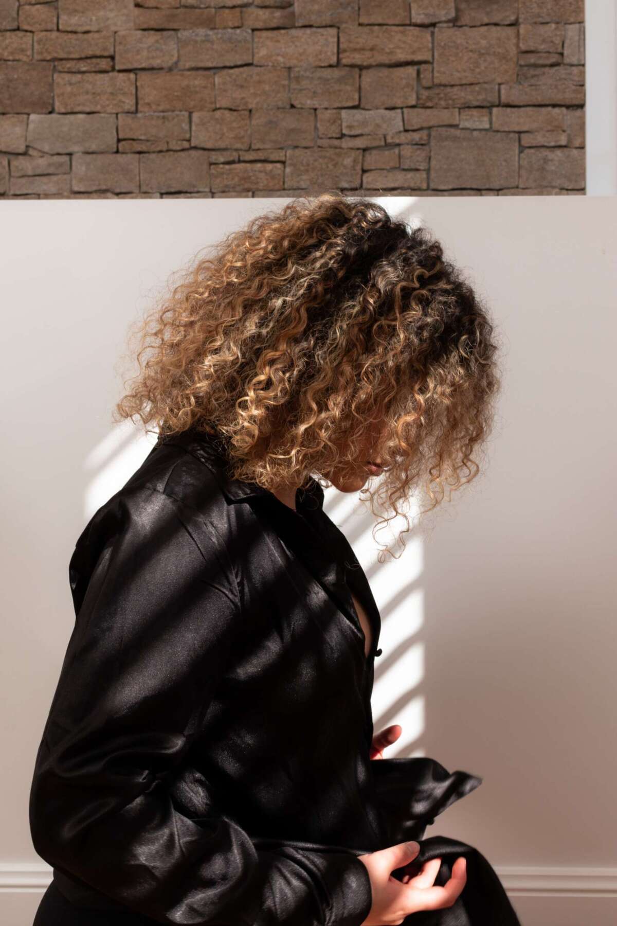 A woman in a black dress with curly hair